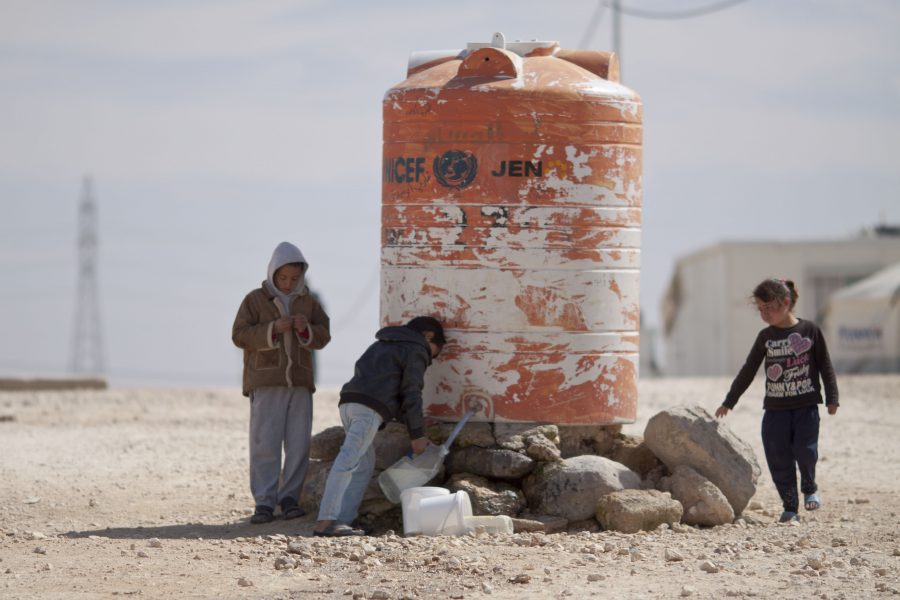 Syrian Children filling drinking water in tanks in Al-Zatari camp for Syrian refugees in Jordan.